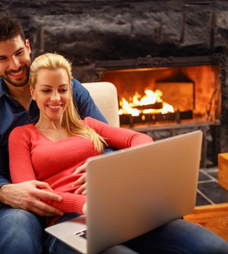 About smiling,couple,with,laptop,spending,time,together,at,home